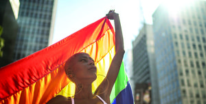 vrouw houdt regenboogvlag omhoog