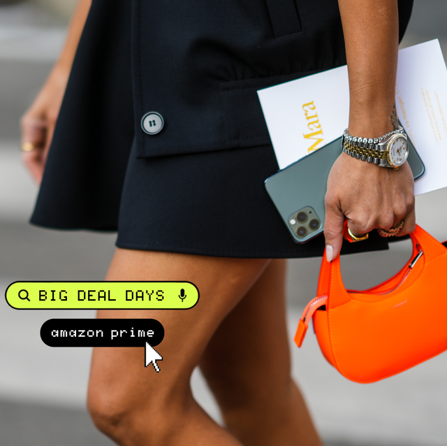 a person holding an orange purse and phone