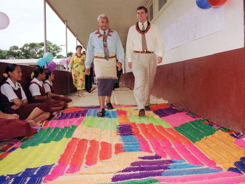 HRH Prince Andrew walks over a handwoven rug with