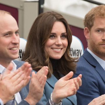 prince william and kate middleton clap at an event, while prince harry looks at them
