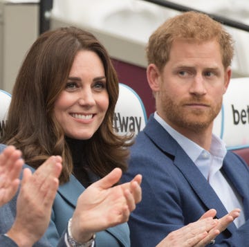 prince william and kate middleton clap at an event, while prince harry looks at them