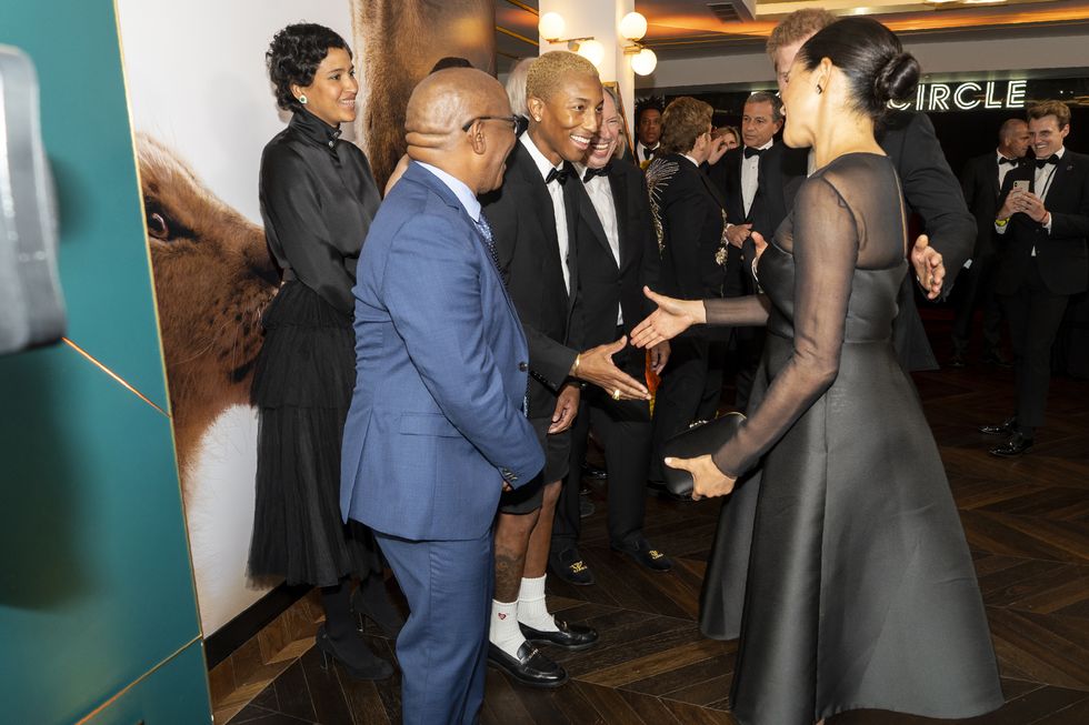 Meghan markle and prince Harry shake hands with Pharrell at The Lion King premiere