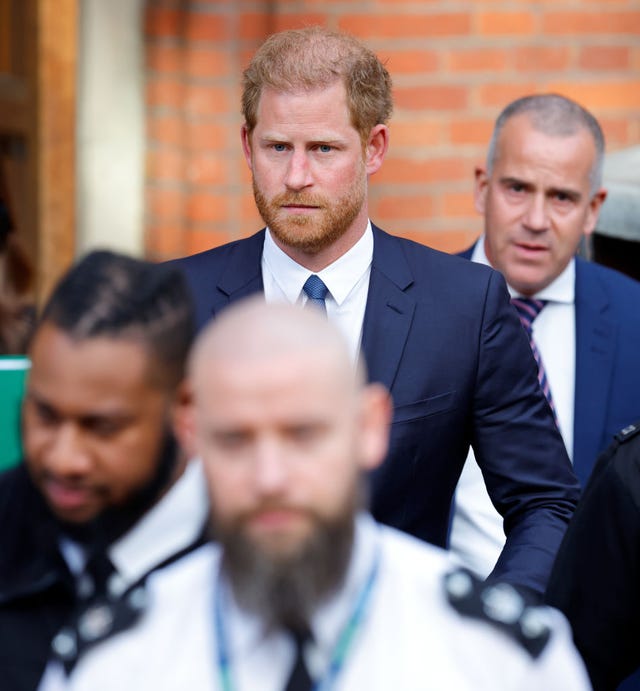 prince harry walking into london high court with escorts