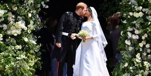 Prince Harry, Duke of Sussex kisses his wife Meghan, Duchess of Sussex as they leave from the West Door of St George's Chapel, Windsor Castle