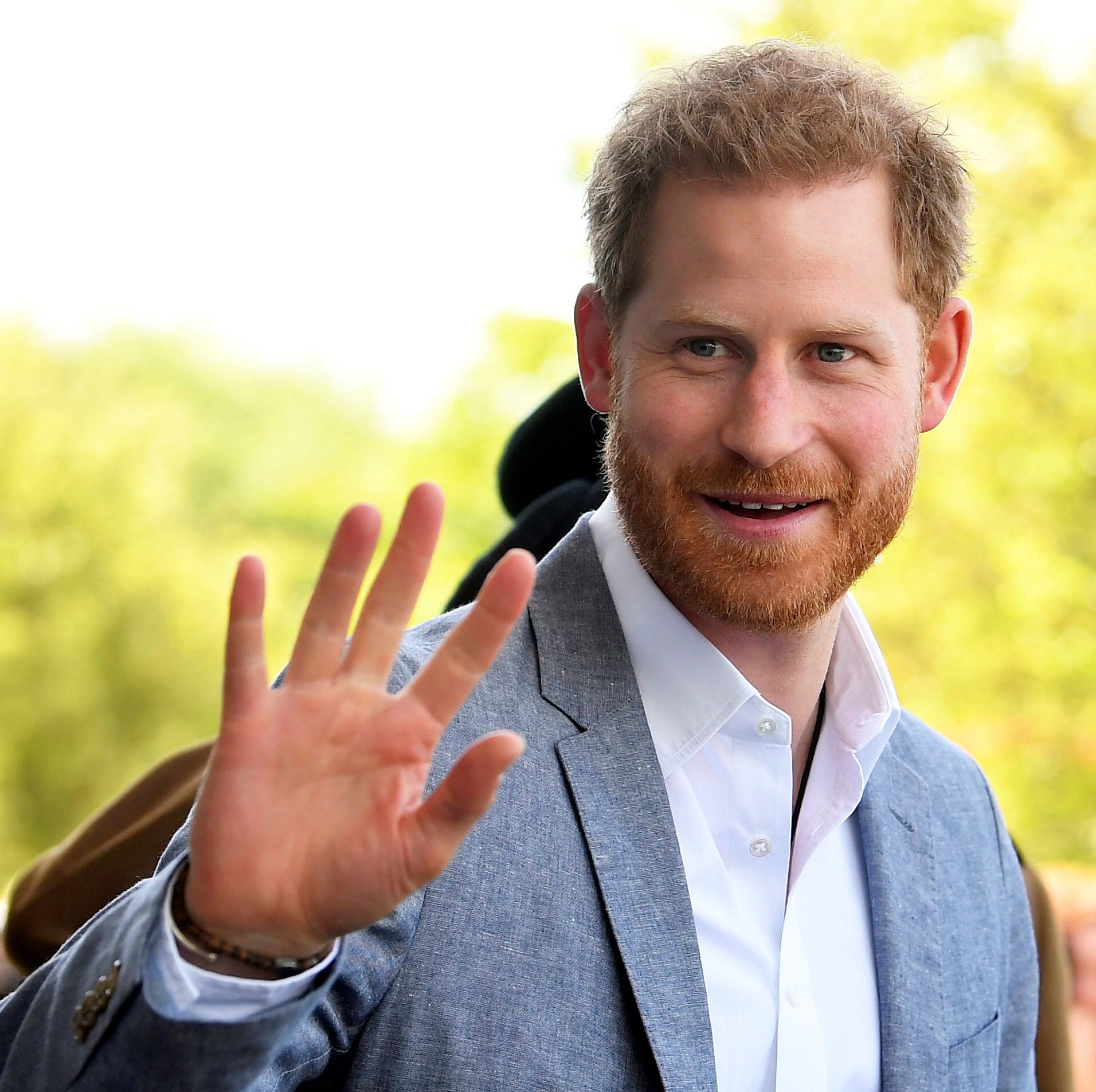 prince harry waving at the camera and smiling
