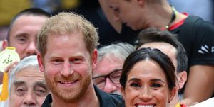 prince harry puts arm around meghan markle at sport event
