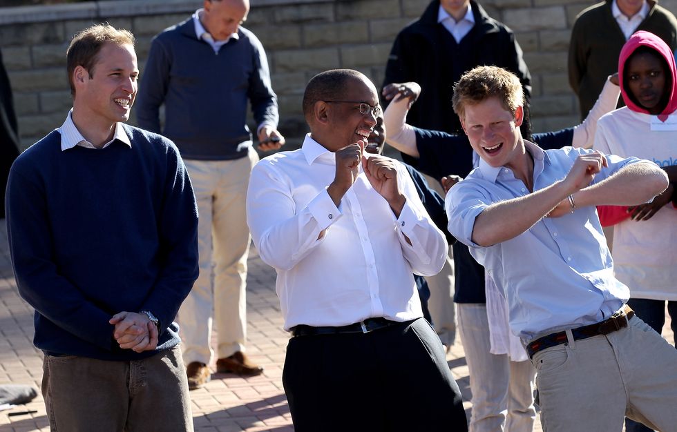 Prince Harry and Prince William dance with Prince Seeiso as they visit the Mamahato Network Club for children affected by HIV at King Letsie's Palace on June 17, 2010 in Maseru, Lesotho.