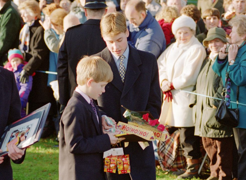 Prince William and Prince Harry hold gifts given to them by