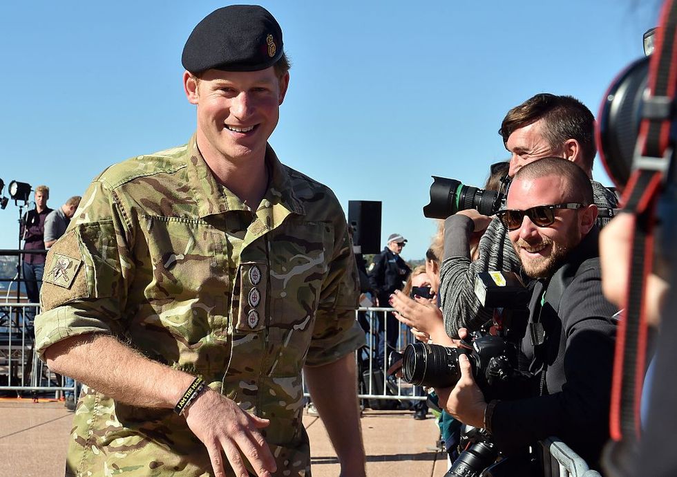 Prince Harry walks past journalists in Sydney, Australia in 2015​