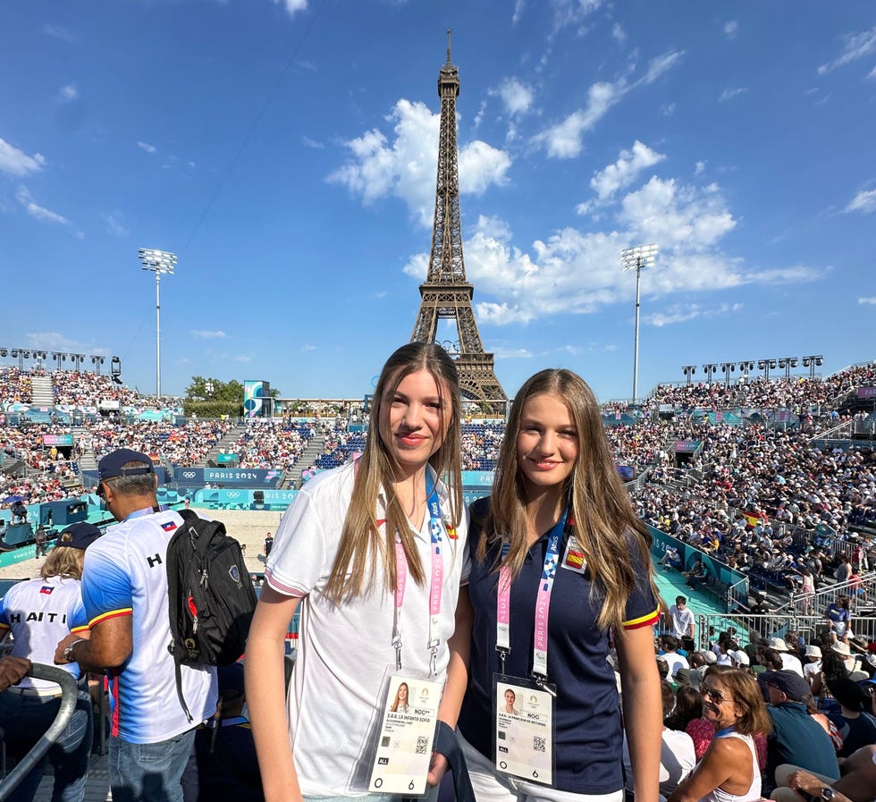 a couple of women posing for a picture in front of a large crowd