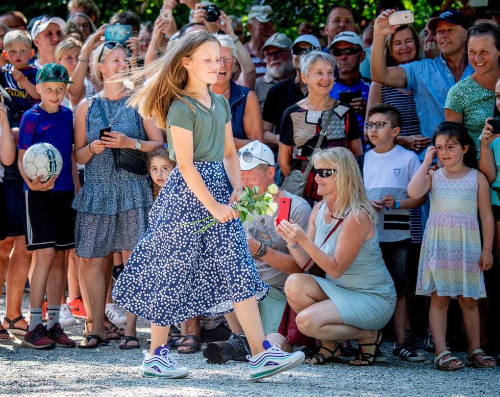 La hija de Federico y Mary de Dinamarca, la princesa Isabella, haciendo una ofrenda floral durante el desfile de caballos de Gratsen Slot