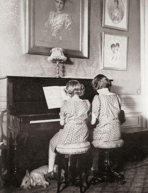 Princess Margaret, left, and Princess Elizabeth, future Queen Elizabeth II, right, playing a duet at the piano in 1940