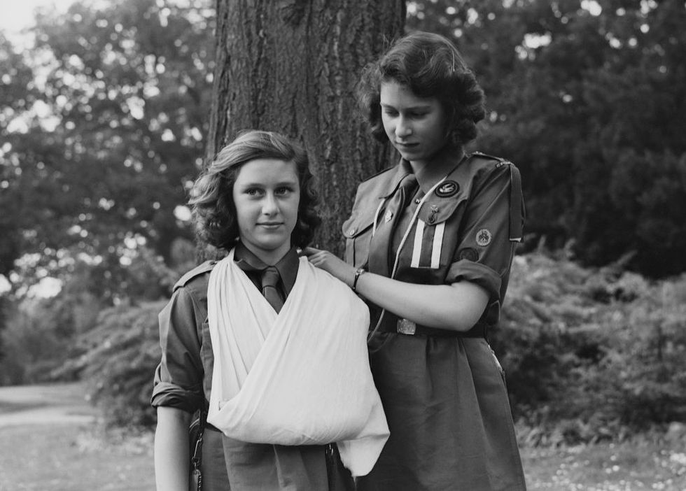 princess elizabeth places princess margaret's arm in a sling as part of the girl guides in frogmore, windsor, england on april 11, 1942  photo by studio lisagetty images