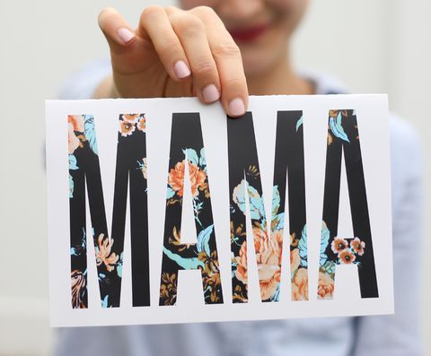 a woman holding a card in front of her that says mama