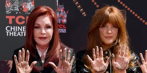 priscilla presley and riley keough look at the camera with their concrete covered palms out