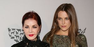 priscilla presley and riley keough embracing in front of a humane society backdrop