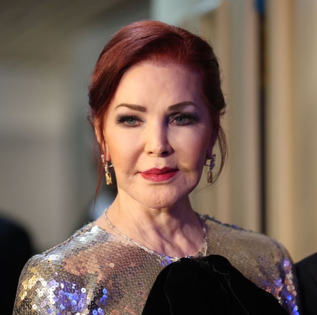 priscilla presley wearing a silver and black dress and smiling for a photograph