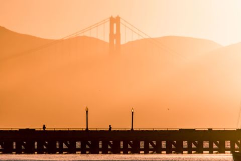 Ik haastte me naar een pier om de zonsondergang achter de Golden Gate Bridge te vereeuwigen toen ik omhoogkeek en de bovenste delen van de brug boven de nevel uit zag steken Het licht zorgde voor zon perfect silhouet van de mensen op de pier dat ik wel moest stoppen om dit vast te leggen