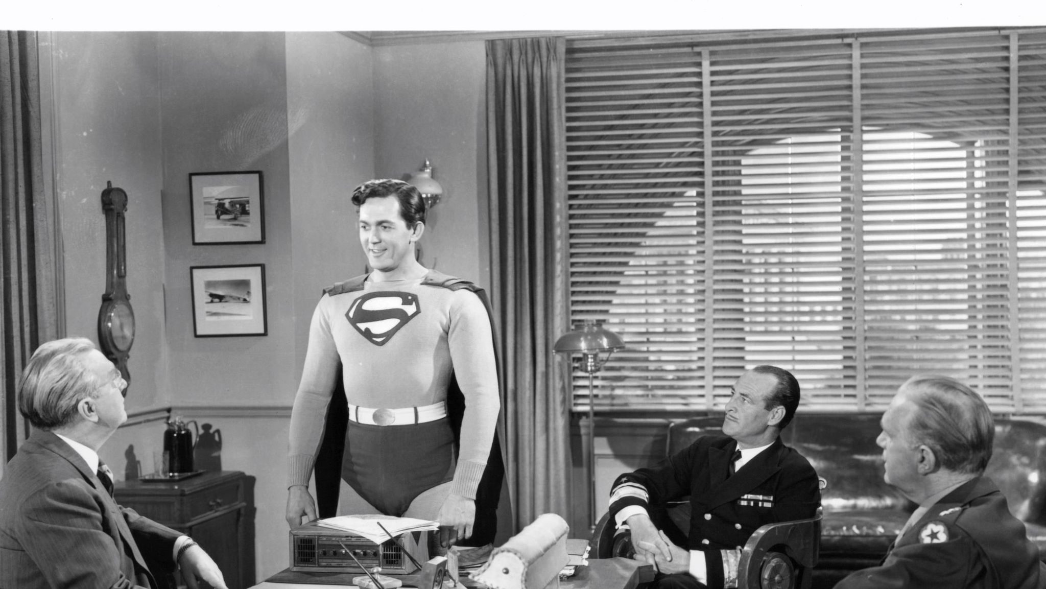 kirk alyn caracterizado como superman en una reunión de trabajo