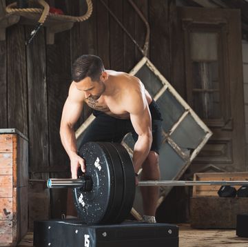 professional athlete putting weights on a barbell