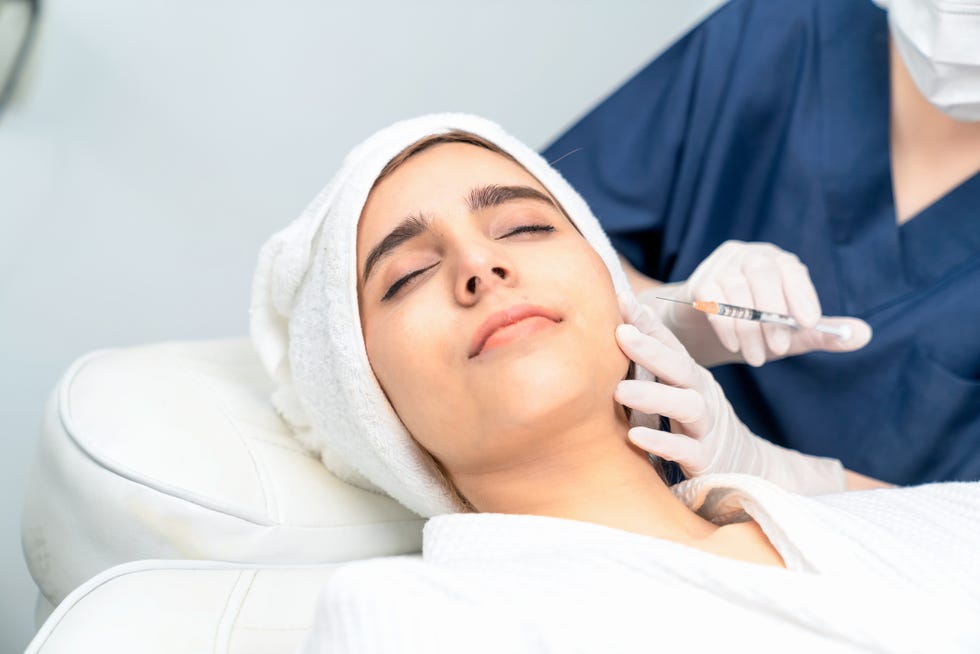 una mujer a punto de recibir un tratamiento de botox a traves de un pinchazo