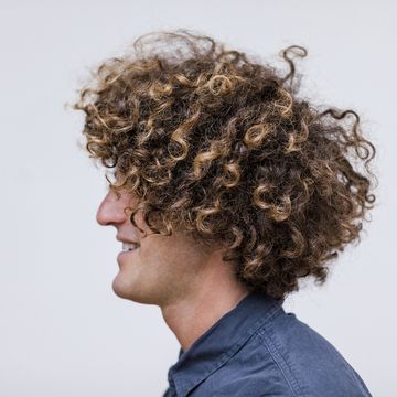 profile of smiling man with curly hair