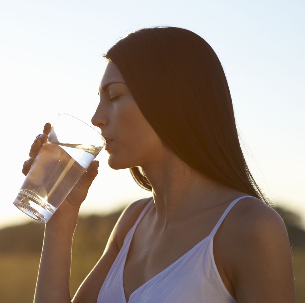 profile of woman drinking water on hot summers day