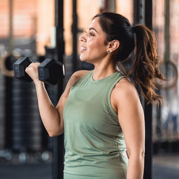 profile view powerful mid adult woman weightlifting at gym