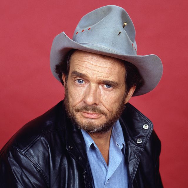 portrait of a younger merle haggard wearing cowboy hat and black leather jacket