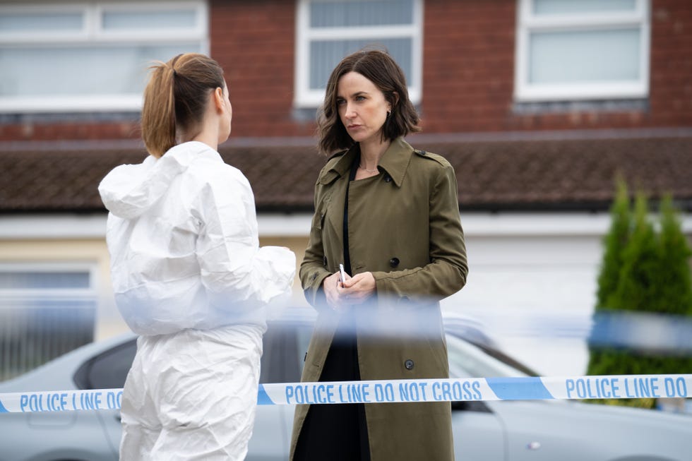 Police investigation scene with two women conversing near a cordoned area