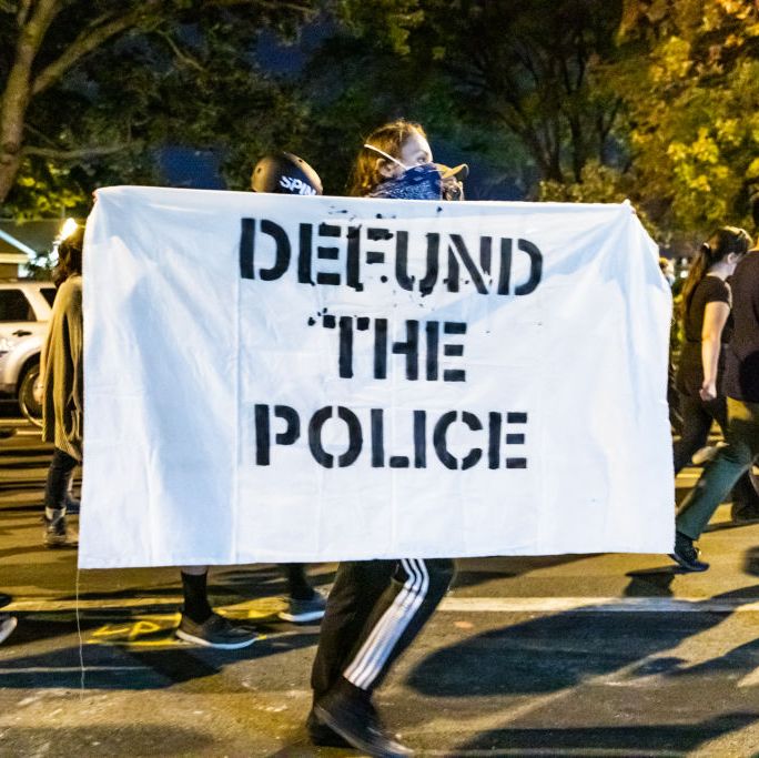 protestor carries "defund the police" sign in chicago in september 2020