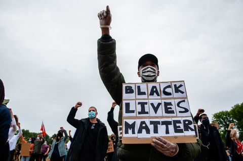 a protester holding a blm placard while making a gesture