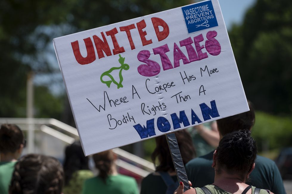 a protester holds a placard reading "united states, where a