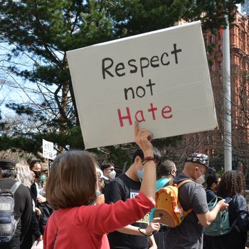 a protester seen holding a placard "respect not hate" near