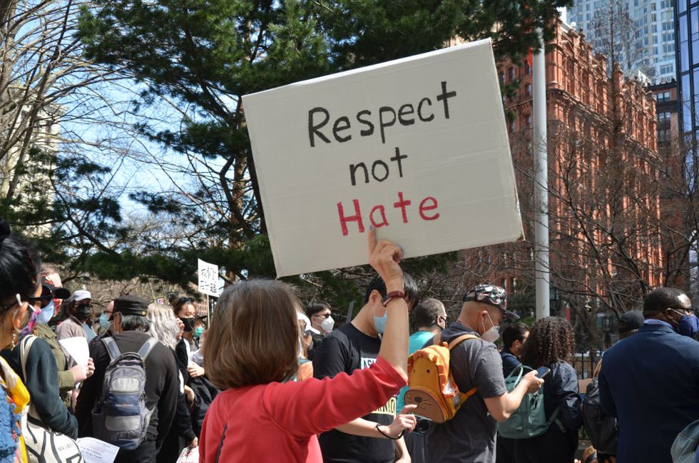 a protester seen holding a placard "respect not hate" near