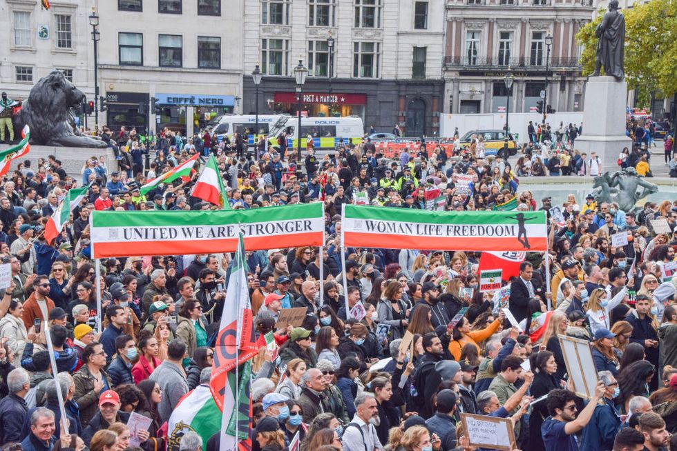 protesters hold iranian flags, and "united we are stronger"