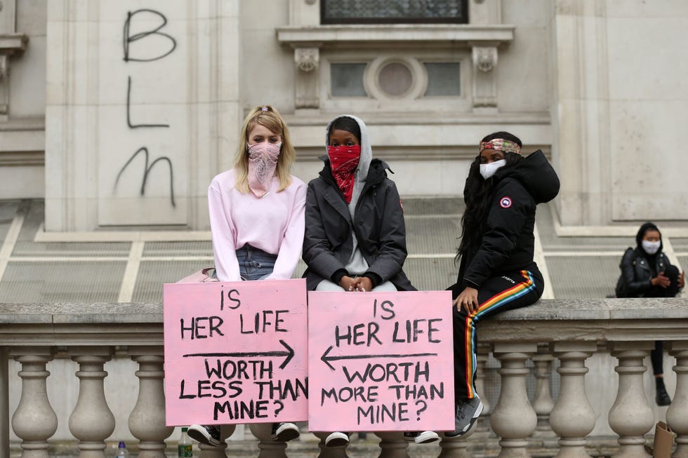 two women holding up signs that say 'is her life worth less than mine' and 'is here life worth more than mine'