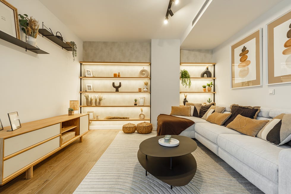 salón con sofá gris, mesas nido negras y estantería de madera a medida