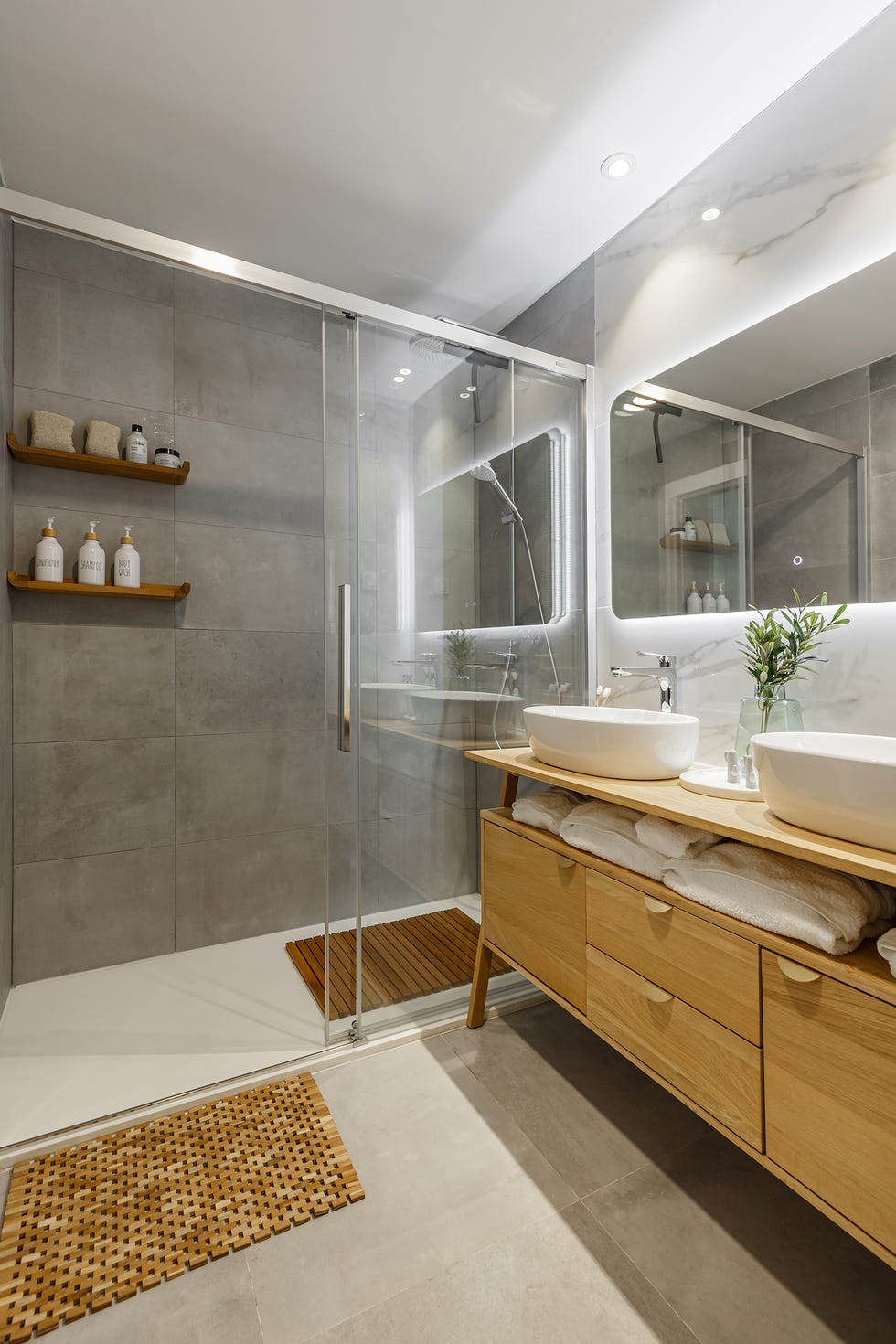 baño con revestimientos de mármol y mueble de madera