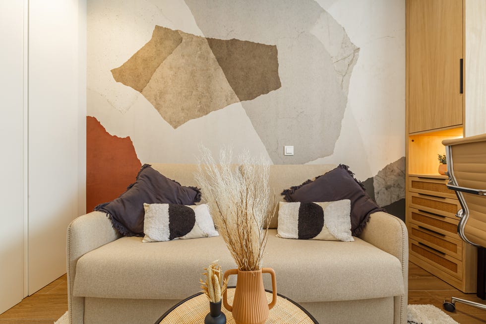 sofá cama beige y mural de colores