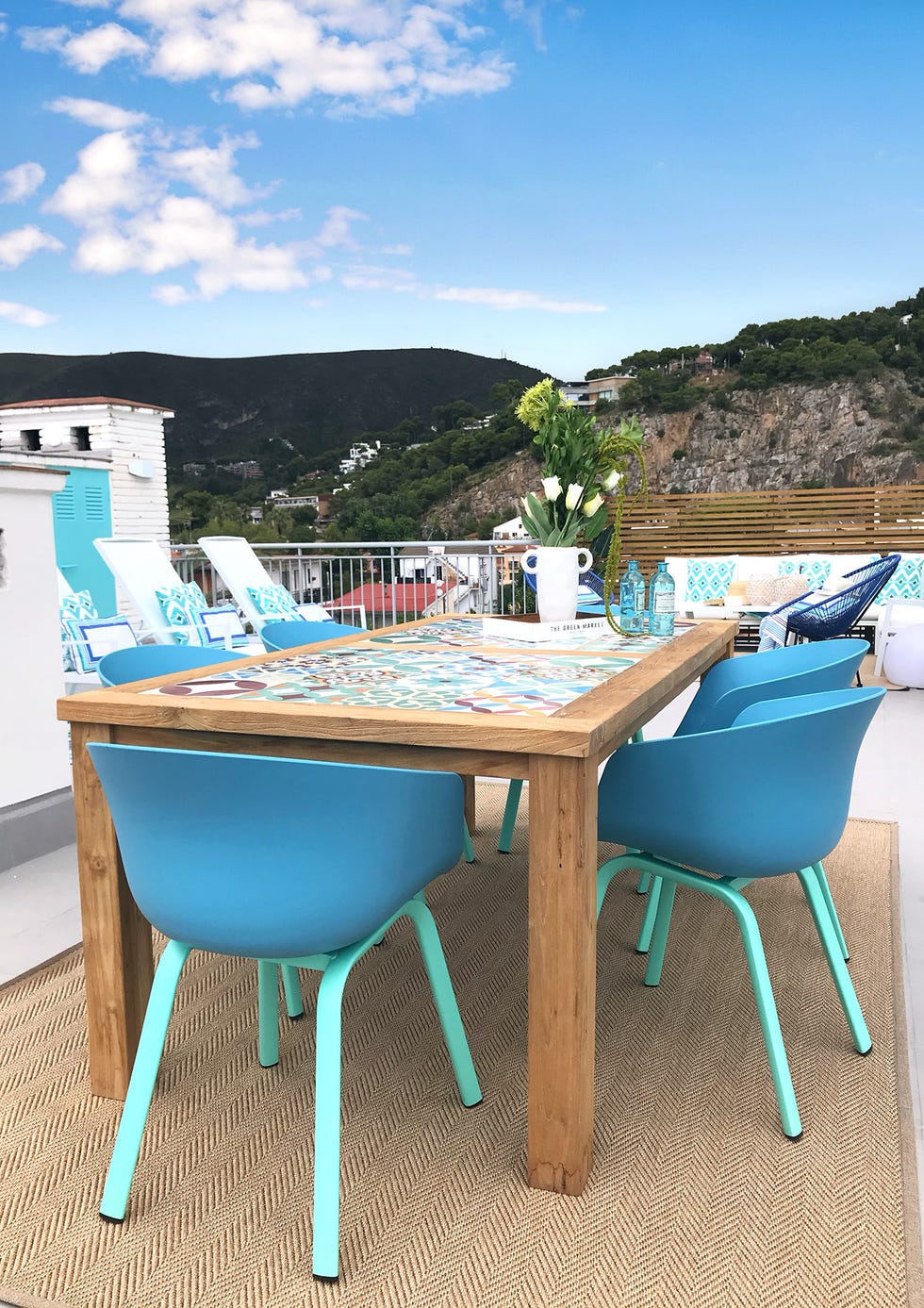 mesa de comedor exterior con sillas azules de estilo mediterráneo