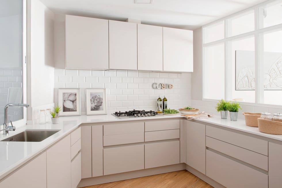 cocina luminosa con azulejos tipo metro blancos y armarios sin tiradores en color beige