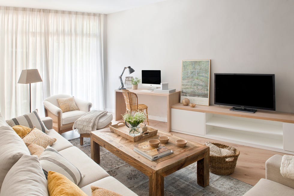salón clásico decorado en color beige con mesa de centro rústica de madera y zona de trabajo