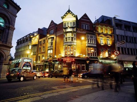 Een helder verlichte pub lokt klanten op zoek naar een biertje in Dublin Een mengelmoes van traditionele Ierse pubs en modernere nachtclubs en cocktailbars vormen samen het bruisende nachtleven van de stad