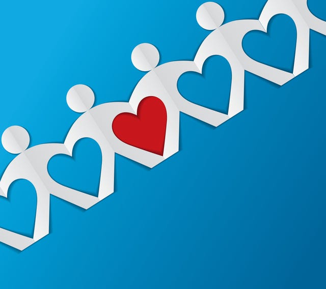 a paper chain of people with a red heart in the middle