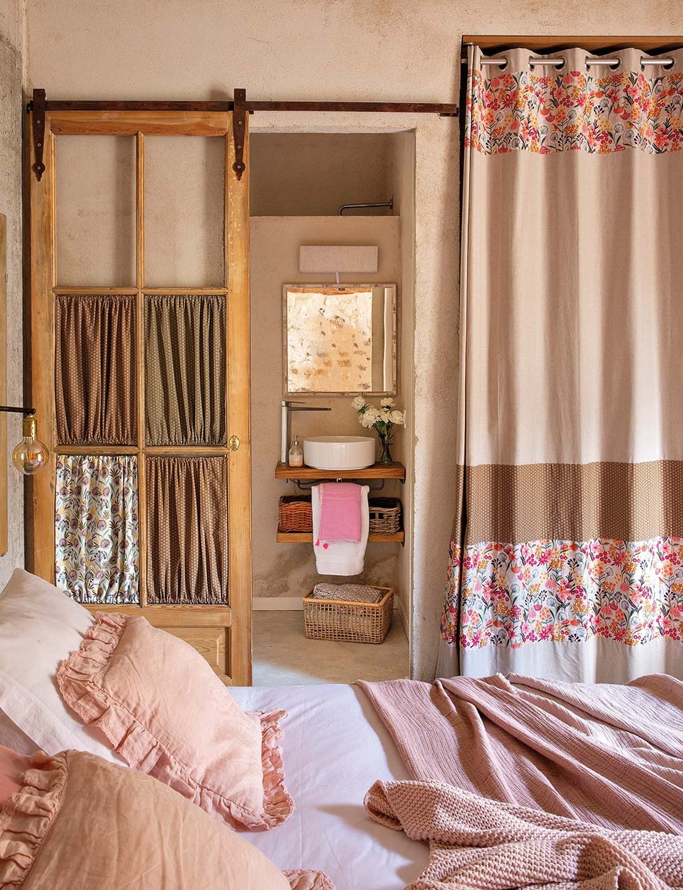 puerta reciclada para hacer una corredera vintage en estilo rústico que separa el dormitorio del baño