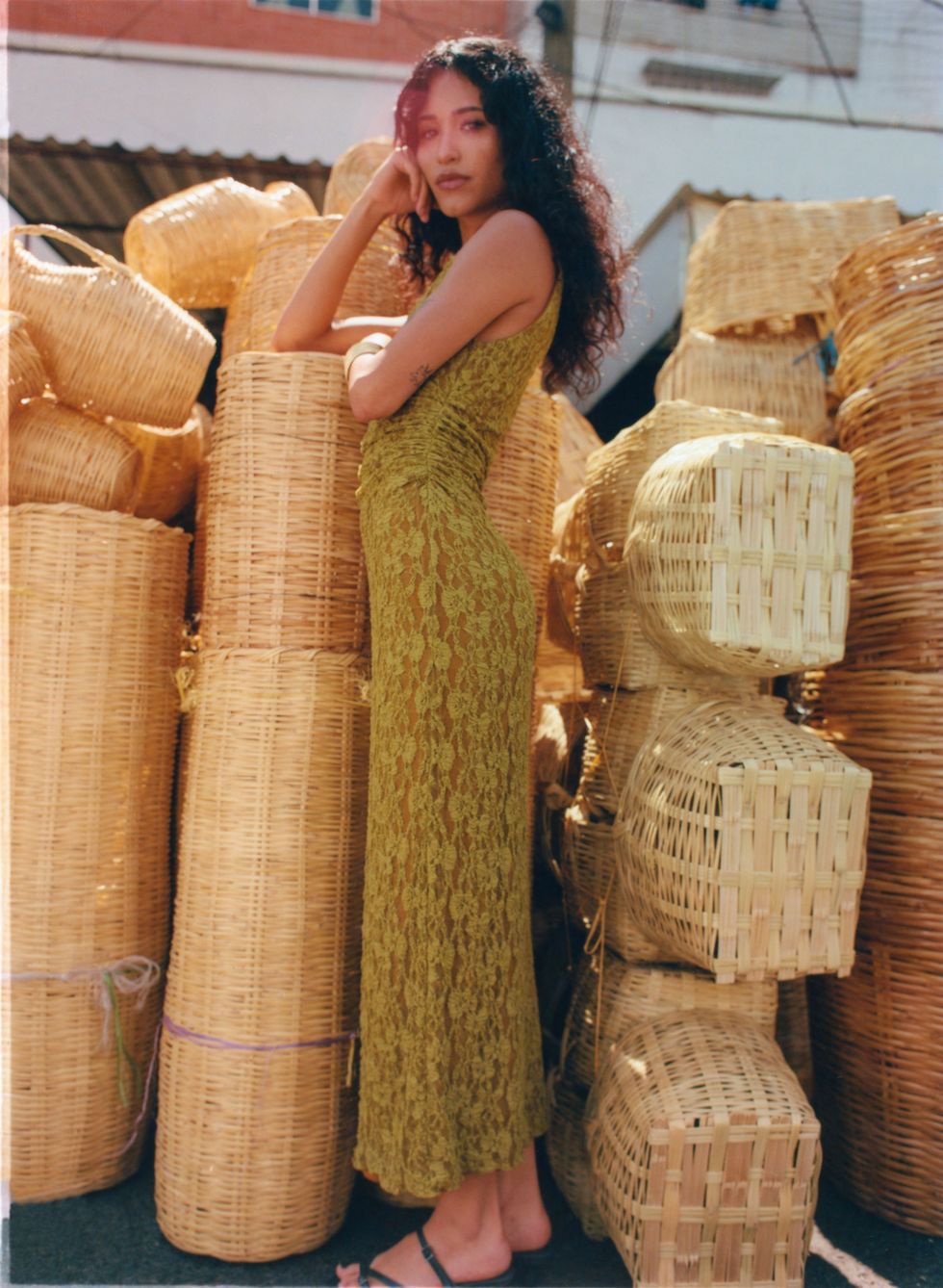 a person in a dress standing next to baskets of bread