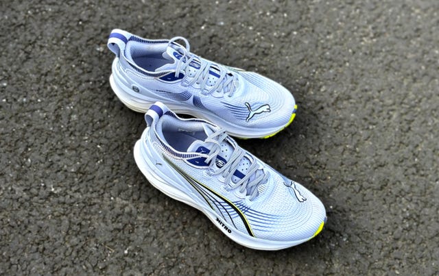 a pair of purple puma nitro running shoes on a tarmac surface