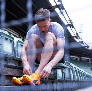 athlete tying shoelaces in stadium seating athlete tying shoelaces in stadium seating