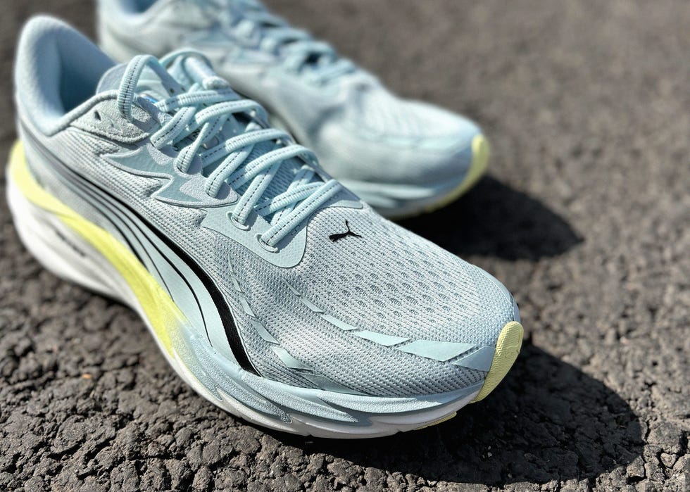 close up of a pair of light blue running shoes on tarmac